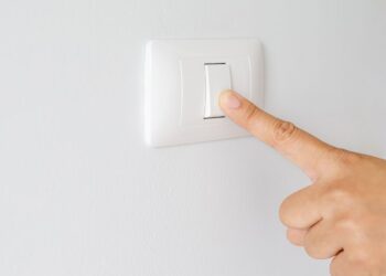 Factura de electricidad junto a una bombilla tras la subida del IVA de la luz al 21%