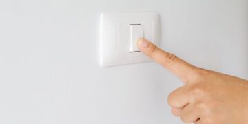 Factura de electricidad junto a una bombilla tras la subida del IVA de la luz al 21%